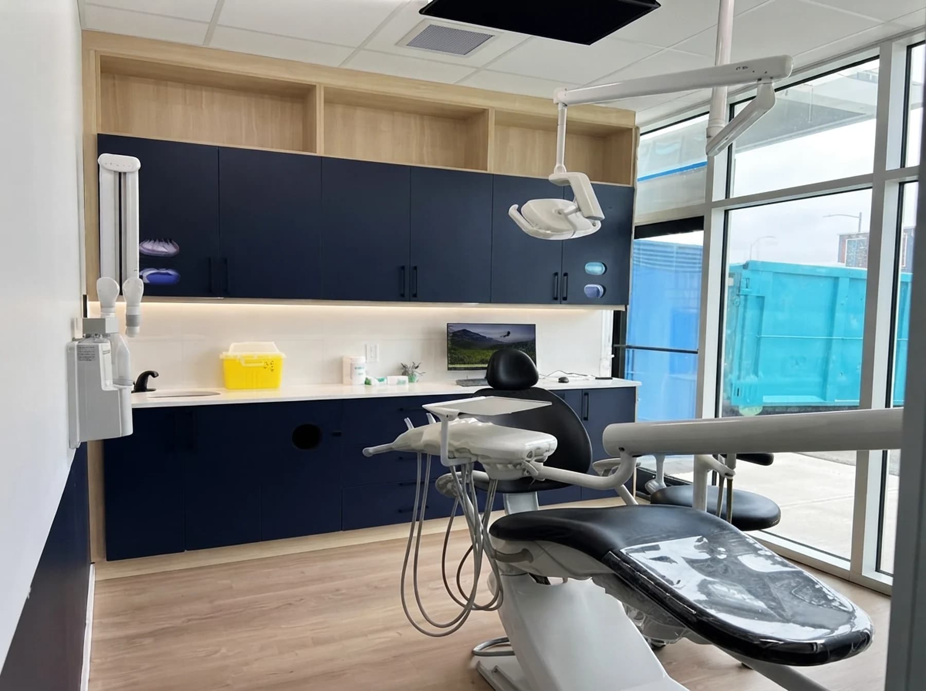 Bright treatment room with a large window and navy cabinetry at Cy Becker Dental in NW Edmonton